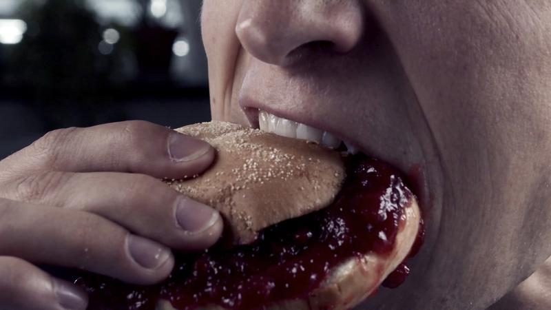 Close up picture of Dylan Hand eating messy jelly sandwich