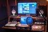 Picture of music studio with computer, speakers, and microphone